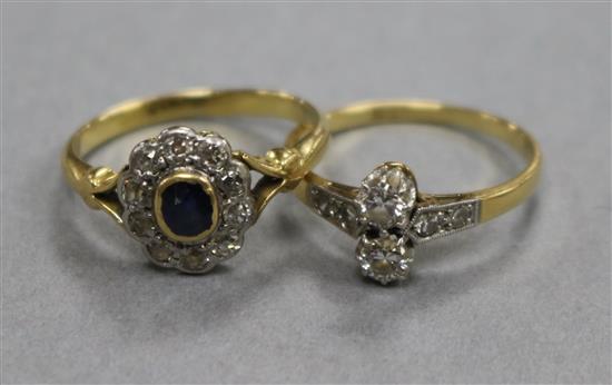 An 18ct gold and platinum, two stone diamond crossover ring with diamond set shoulders and a sapphire and diamond cluster ring.